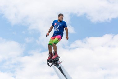 Side, Türkiye - 1 Haziran 2018: Yakışıklı tabaklanmış adam sineklikte duruyor ve bulutlarla mavi gökyüzüne uçuyor.