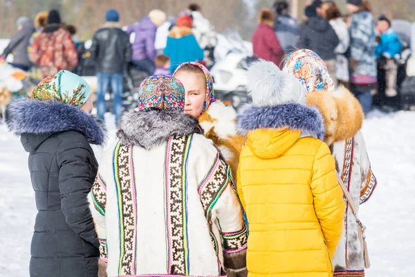 ラスキンスカヤ、ロシア - 2018年3月24日:ダウンジャケットと国民的な服を着た先祖の女性が中央広場に立っています。トナカイの飼料の休日. — ストック写真