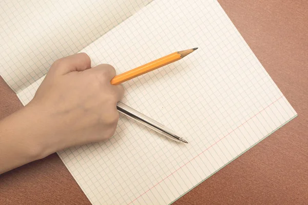 鉛筆とペンを持った女子高生の手 — ストック写真