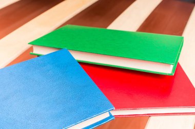 Çok renkli kitaplar yatak odasında yataktan ahşap bir kafes üzerinde yalan