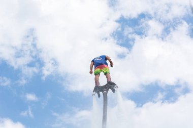 Side, Türkiye - 1 Haziran 2018: Yakışıklı tabaklanmış adam sineklikte duruyor ve bulutlarla mavi gökyüzüne uçuyor.