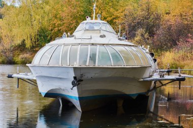 İnsanları taşımak için terk edilmiş büyük tekne göl kıyısında duruyor.