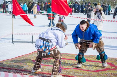 Russkinskaya, Rusya - 24 Mart 2018: Kuzey deki ulusal giyimli iki klan üyesi, merkez meydanda halk için ellerinde güreşen erkeklerle uğraşıyor. Benim aramdaki mücadele için rekabet