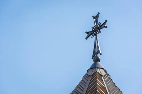 Hermosa cruz de una iglesia armenia contra un cielo azul . — Foto de Stock