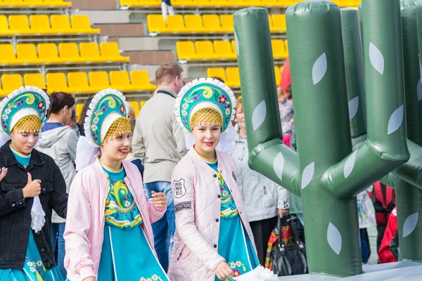 SURGUT, RUSIA - 2 DE SEPTIEMBRE DE 2018: Hermosas chicas en trajes inteligentes van a actuar en el escenario en el conjunto. Trabajadores de la industria del petróleo y el gas . —  Fotos de Stock