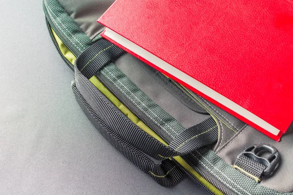 Red book lays the laptop bag