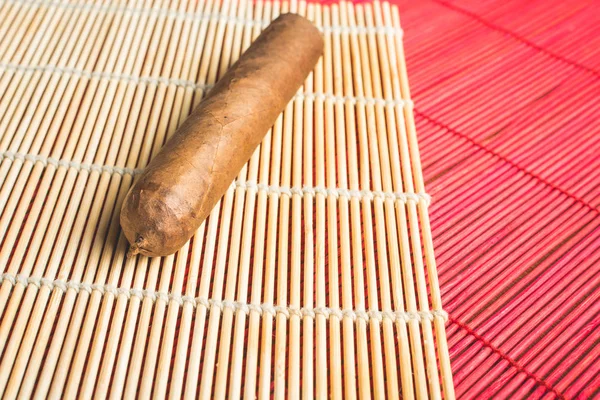 Cuban cigar on white bamboo mat. — Stock Photo, Image