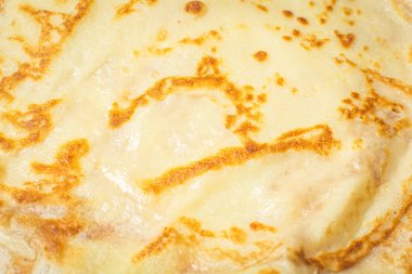 Mutfak masasında tabakta kızarmış yuvarlak krep.