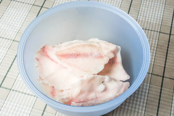 Frozen tilapia fish in deep defrosting bowl. — Stock Photo, Image