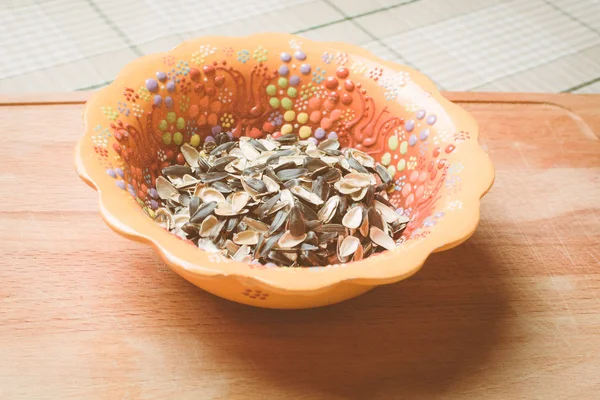Оболочка, оставшаяся от семян в красивой тарелке на деревянной доске . — стоковое фото