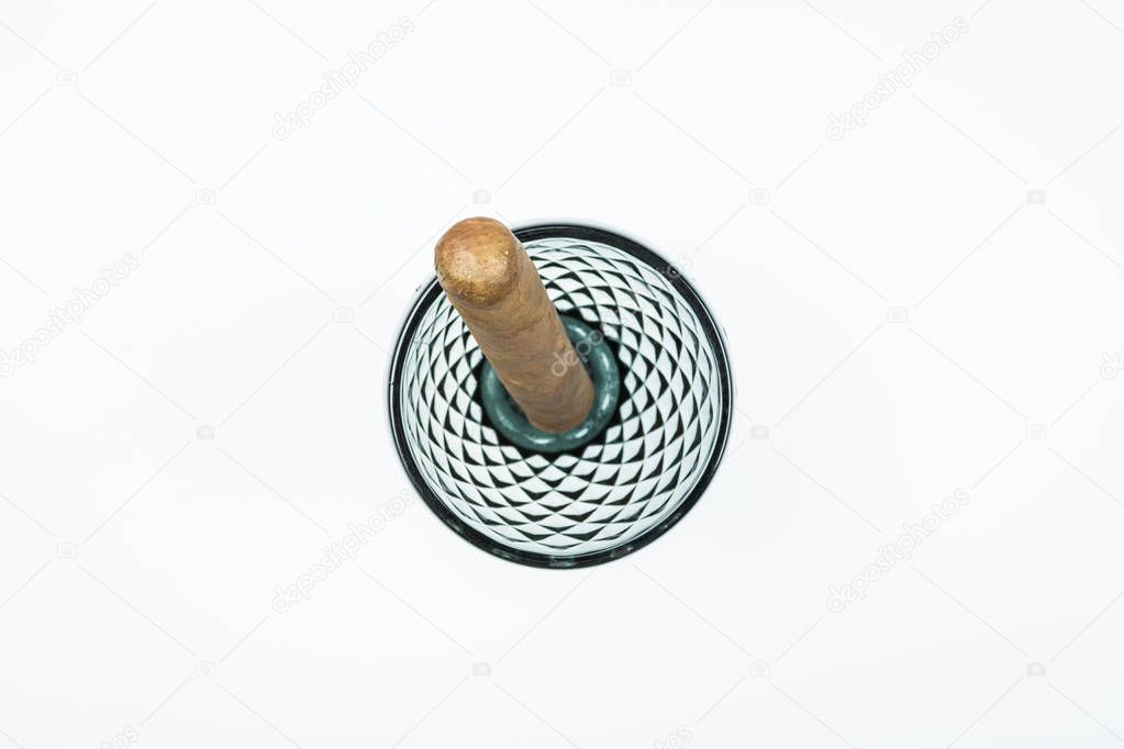 Cuban cigars from twisted sheets in glass beaker with white background.