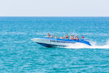 Side, Turkey - 02 Haziran 2018: Mavi denizde büyük tekneyle koşan bir grup turist.