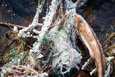 Balıkçılık için atılmış donmuş ağ nehirdeki engele asılı..