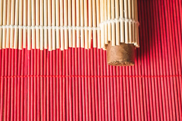 Precioso cigarro envuelto en estera cuadrada de bambú . — Foto de Stock