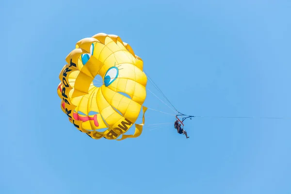 SIDE, TURKEY - MAY 31, 2018: Yellow parachute with tourists flies in sky tied to boat. — Stock Photo, Image