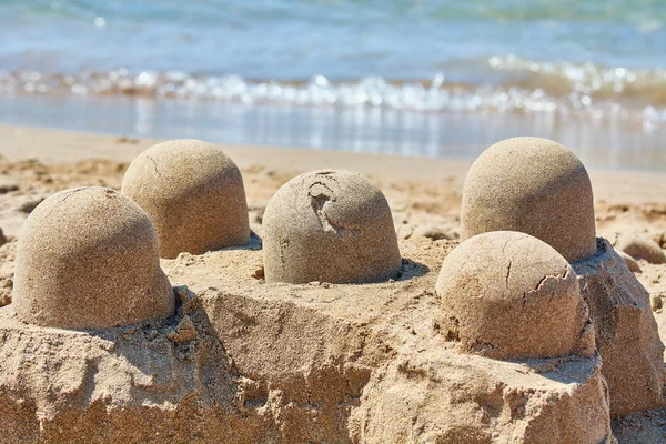 Sand castle made by childrens bucket on beach. — Stock Photo, Image