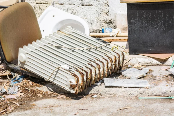 Alter rostiger Heizkörper liegt auf dem Mülleimer. — Stockfoto