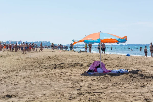 Seite, Türkei - 02. Juni 2018: großer Sonnenschirm für Chaiselongue am Sandstrand mit Touristen. — Stockfoto