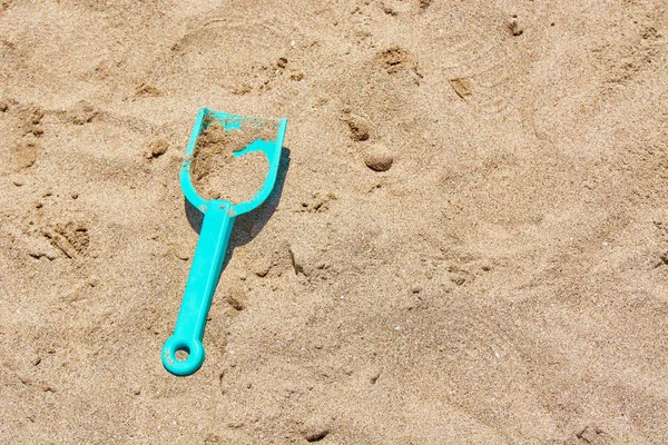 Childrens blue shovel in sandbox for game. — Stock Photo, Image