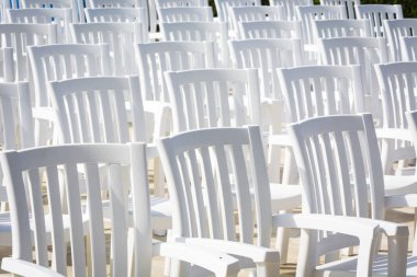 White loose chairs with backrest in summer theater for watching performances on stage