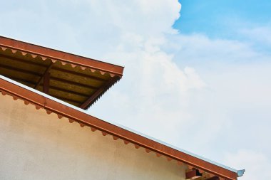 Bulutlar ile mavi gökyüzüne karşı büyük kereste bina çatı