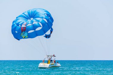 Side, Türkiye - 31 Mayıs 2018: Mavi denizde hızla giden teknenin hızından turistlerle mavi paraşüt gökyüzüne yükseliyor