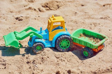 Plaj kumlu kıyısında römork ile Çocuk oyuncak traktör