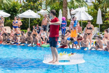 Side, Turkey - 2 Haziran 2018: Giysili adam havuzda masada duruyor ve turistleri eğlendirdi.