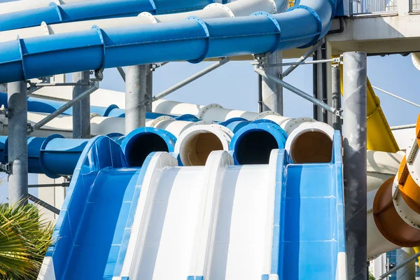 Toboganes de agua empinados con tuberías en el parque acuático . — Foto de Stock