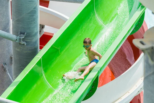 SIDE, TURQUIE - 02 JUIN 2018 : Un petit garçon avec des lunettes descend la glissière d'eau . — Photo