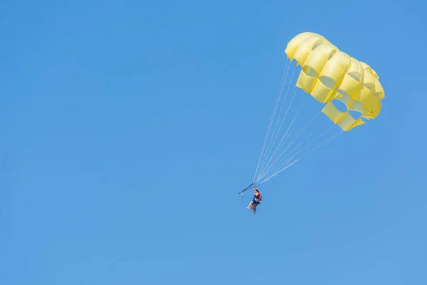 SIDE, TURKEY - JUNE 02, 2018: Yellow parachute with tourists flies in sky tied to boat. — Stock Photo, Image