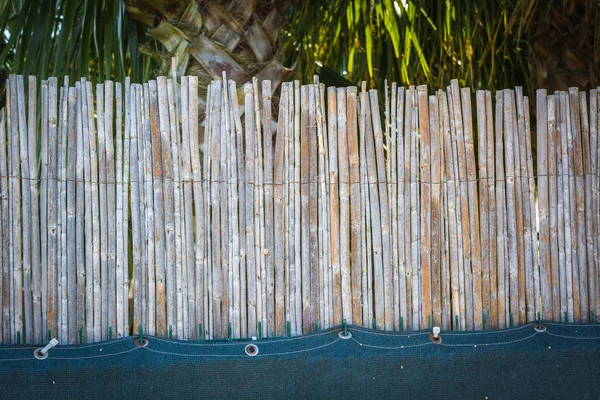 Hoher Zaun aus dünnen Bambusstäben. — Stockfoto