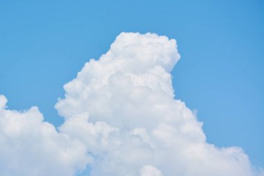 Fluffy white clouds hung in blue sky. clipart