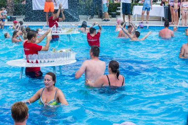 Side, Turkey - 2 Haziran 2018: Havuzdaki masalarda barmenler banyo yapanlara şampanya sıçratıyor.