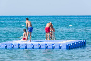 Side, Turkey - 02 Haziran 2018: Denizde dalış ve yüzme için mavi yüzer köprüde tatilciler.