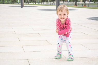 Sıcak kazak neşeli çocuk şehir sokakta yürüyor.