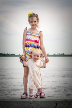 Nehirde iskelede yürüyen iki güzel kız kardeş