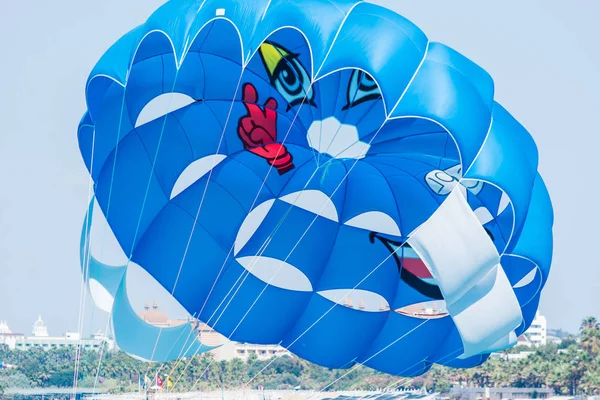 SIDE, TURKEY - JUNE 02, 2018: Blue parachute with tourists rises into sky from speed of boat speeding through blue sea. — Stock Photo, Image