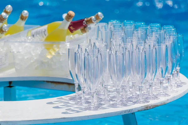 SIDE, TURQUIA - JUNHO 02, 2018: Copos de vidro e garrafas de champanhe na mesa em piscina azul . — Fotografia de Stock