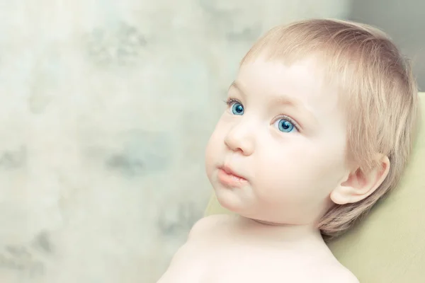 Criança bonita com grandes olhos azuis sentados na cadeira da cozinha . — Fotografia de Stock