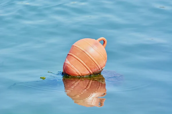 Orange buoy for walking ships and boats in blue sea.