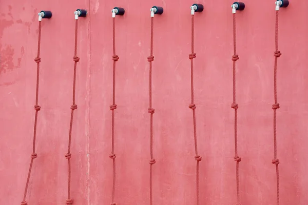 Červená lezecká stěna s dlouhými provazy. — Stock fotografie