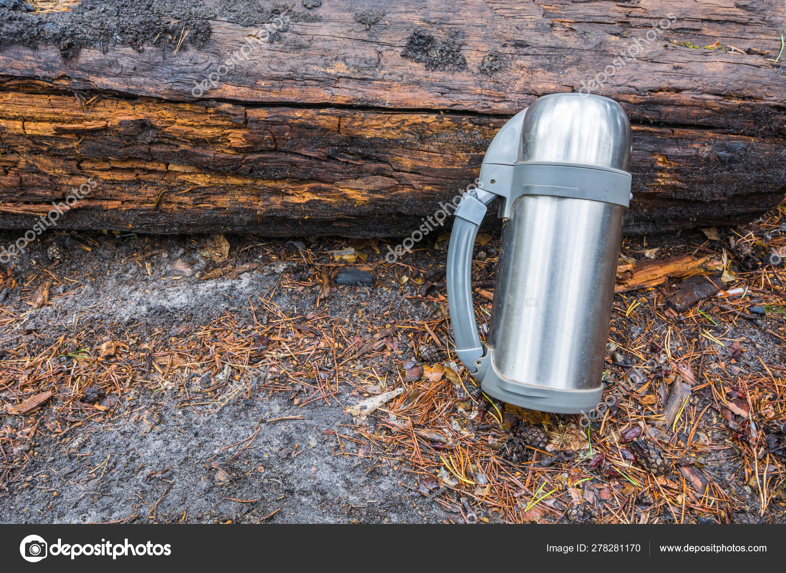 Voluminous marching thermos for hot tea or coffee stands on ground