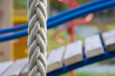Çocuklar için oyun alanında slayt yakın tırmanma için beyaz ip kablosu.