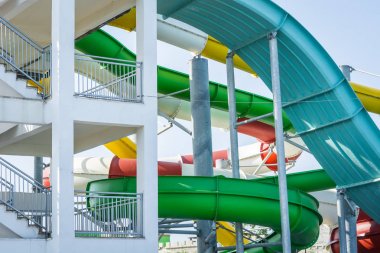Aquapark'ta merdivenlerin yanında çok renkli su kaydırakları.
