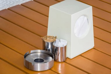 Restoran masasında kül tablaları, peçeteler ve kürdanyemek seti.