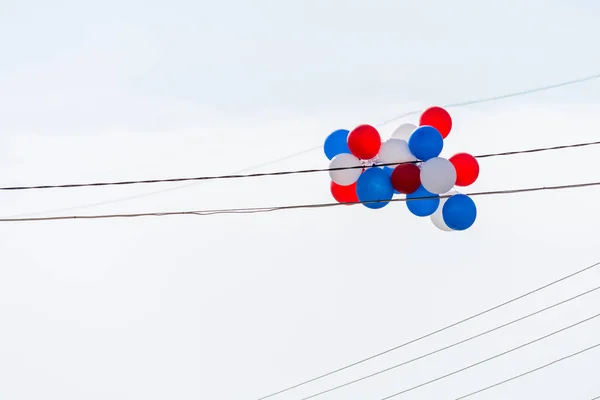 Boules multicolores d'air accrochées à des fils électriques contre le ciel . — Photo