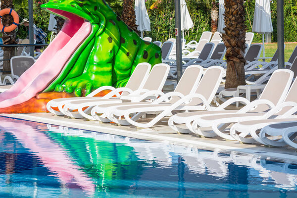 Бесплатные шезлонги для отдыха и принятия солнечных ванн на краю синего бассейна
.