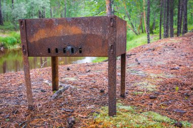 Ormanda taiga nehri arka planda şiş kebap için turistik barbekü.