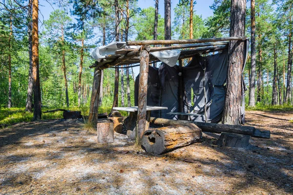 Mens hut with table and stumps the forest among trees. — Stock Photo, Image